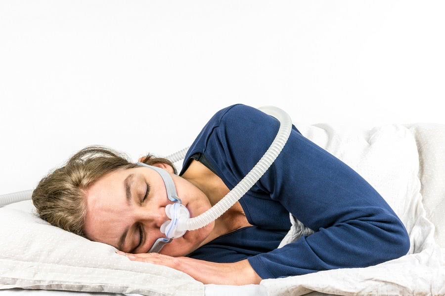 Woman Sleeping With Assistance of CPAP Machine - a Common CPAP Therapy Solution